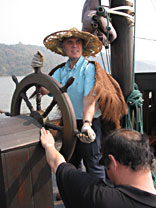 Peter steering a sailing junk on Lake Taihu