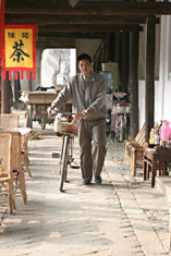 Guesthouse owner Mr Song returns from market with his duck