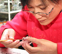 Woman painting inside perfume bottle